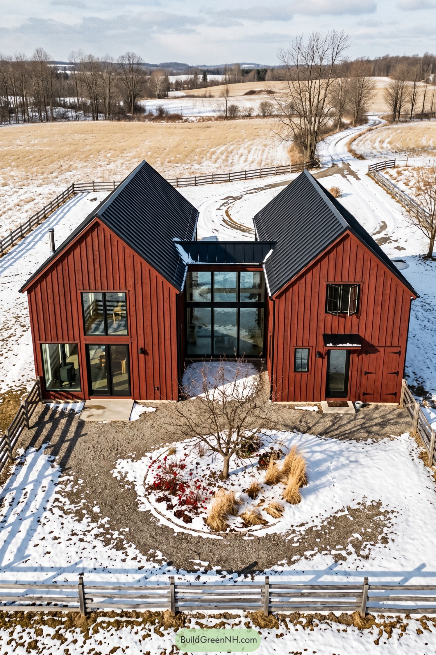 Twin red barn volumes joined by a glazed central hall in a snowy field