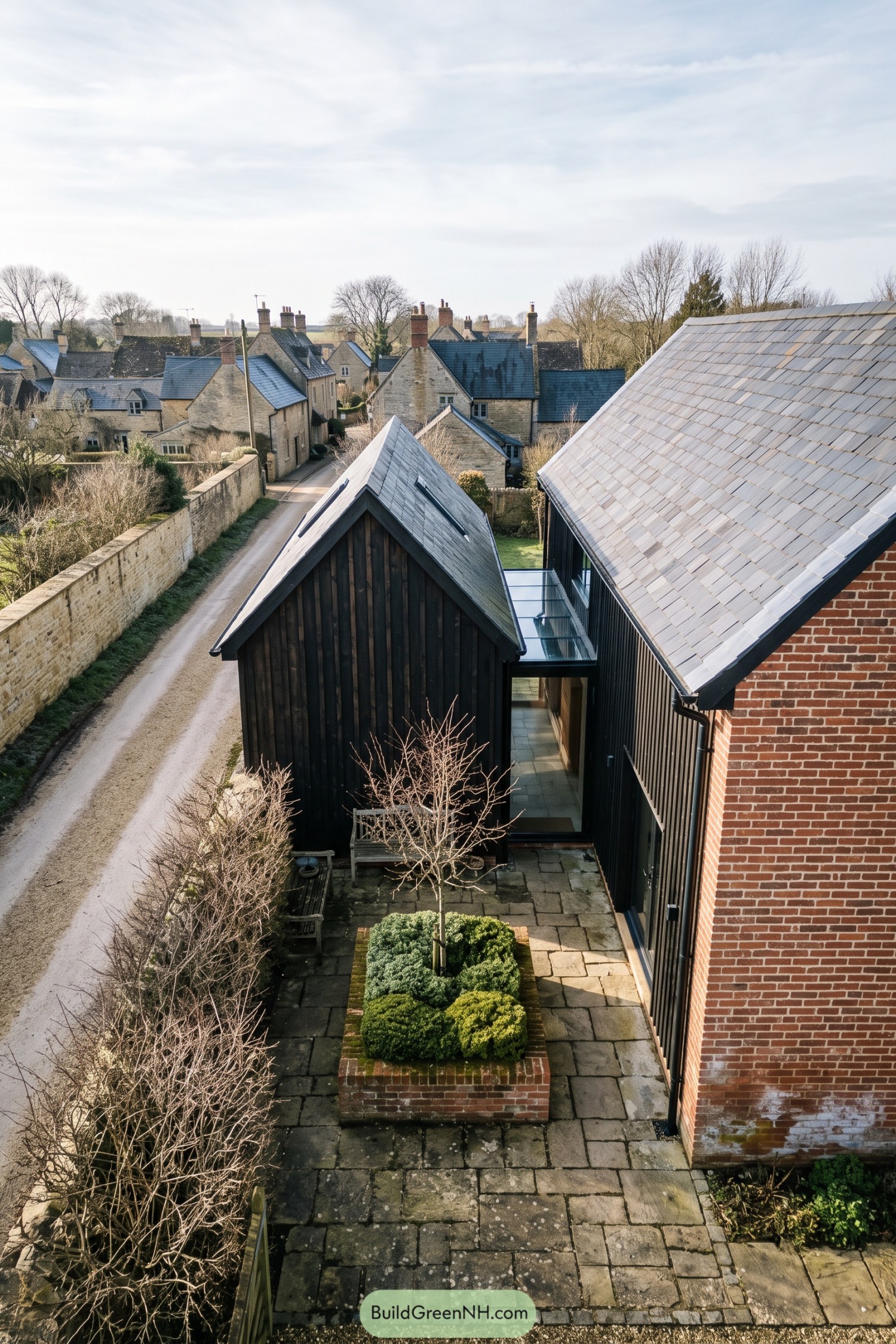 Twin black-clad gabled volumes beside a brick wing